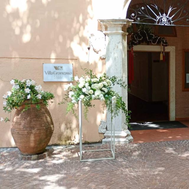 Ingresso elegante con fiori bianchi e verde, atmosfera accogliente e raffinata.
