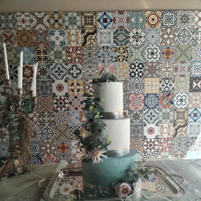 Torta elegante su sfondo di piastrelle colorate, atmosfera romantica e artistica.