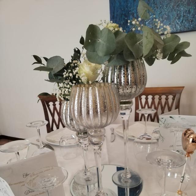 Elegante tavola con calici e fiori, atmosfera raffinata e serena.