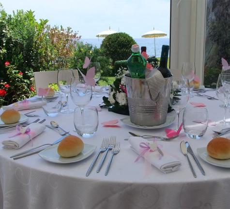 Table set with pink butterfly decorations and sea view.