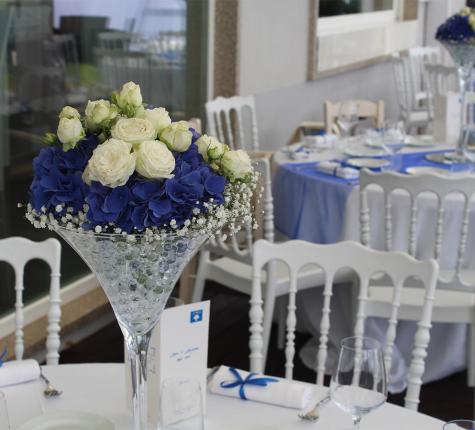 Elegant table with white and blue flowers in a glass vase.