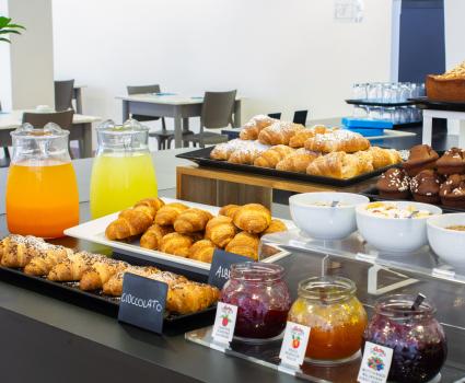 Buffet dolce con croissant, muffin e succhi, perfetto per una colazione invitante.