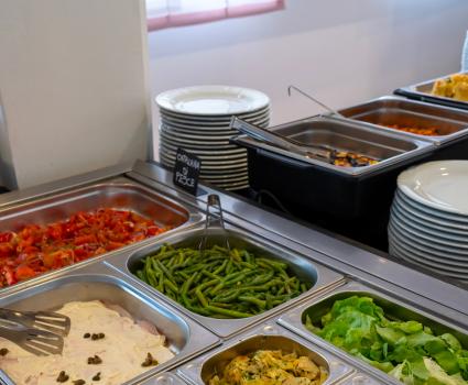 Buffet colorato con verdure fresche e piatti invitanti, un'esplosione di sapori.