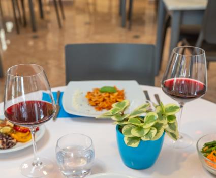 Pranzo elegante con vino rosso, piatto di pasta e pane fragrante.