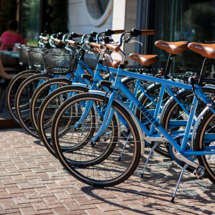 Blue bicycles parked outside a café with outdoor chairs and tables.