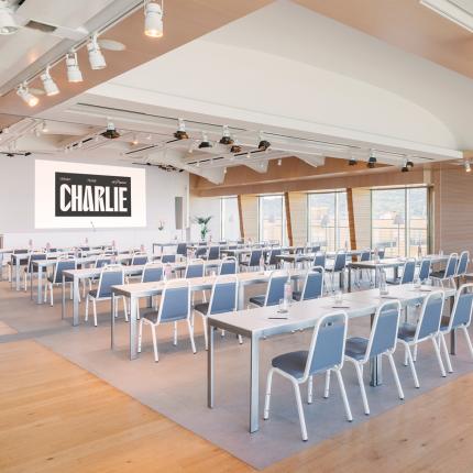 Modern conference room with tables and chairs, lighting, and panoramic view.