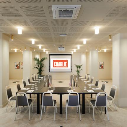 Modern conference room with U-shaped tables and projector.