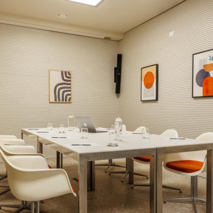 Modern meeting room with white table and stylish chairs.