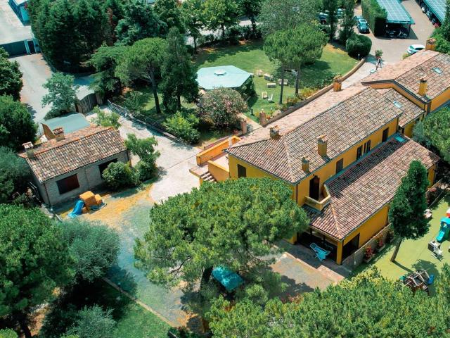 Vista aerea di una villa con giardino e giochi per bambini.