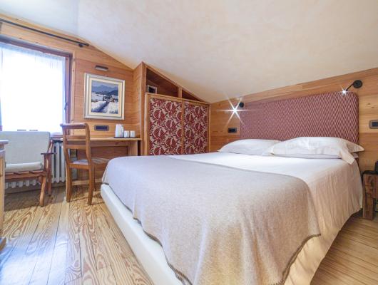 Camera accogliente con letto matrimoniale e arredamento in legno.