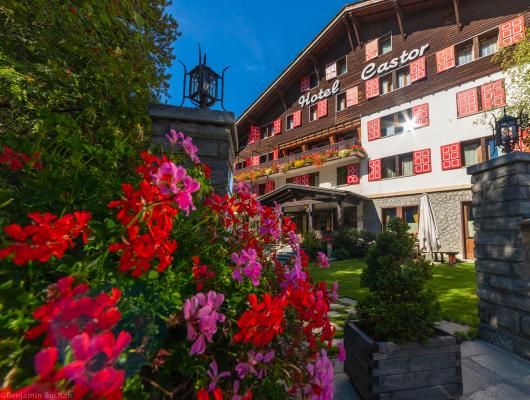 Hotel accogliente con fiori colorati e finestre rosse.