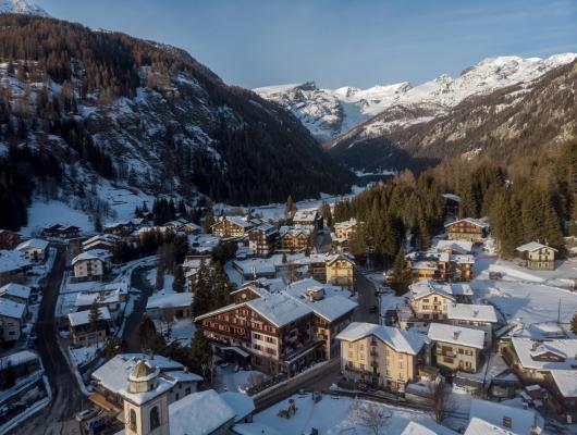 Un pittoresco villaggio alpino innevato circondato da montagne.