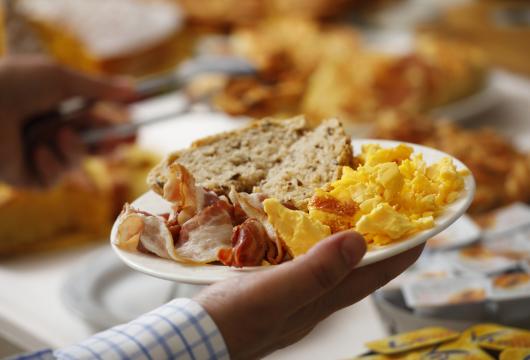 Colazione con uova strapazzate, pancetta e pane.