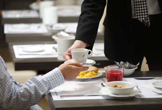 Colazione servita con caffè, succo e cereali in un ristorante.