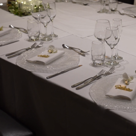 Eleganter Tisch mit Tellern, Besteck, Gläsern und Lichterdekorationen.