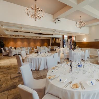 Elegante sala da pranzo con tavoli rotondi, luci soffuse e atmosfera raffinata.