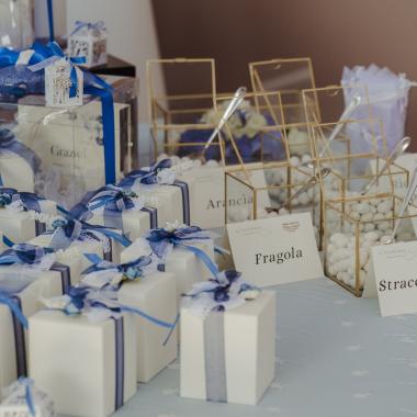 Tavolo elegante con confetti colorati e scatole regalo decorate.