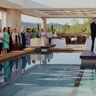 Coppia felice festeggia matrimonio all'aperto con amici e piscina.