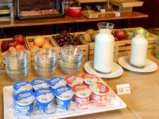 Buffet colazione con frutta, yogurt e latte.