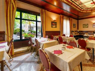 Sala da pranzo elegante con sedie rosse e finestre luminose.