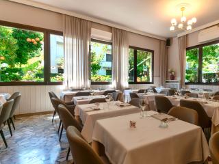 Ristorante elegante con finestre luminose e tavoli apparecchiati.