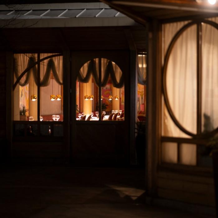 Cozy restaurant, warm lights, intimate and inviting atmosphere.