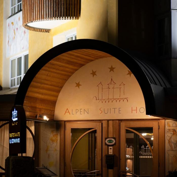 Elegant mountain hotel entrance, warm and welcoming atmosphere at night.