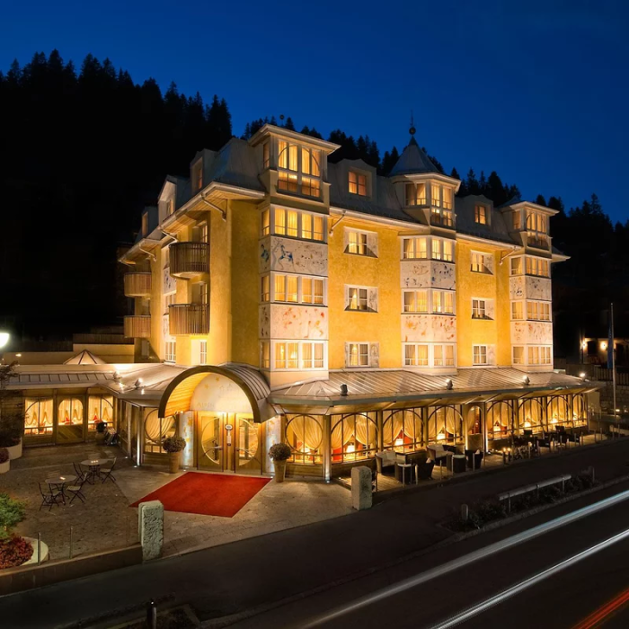 Elegant hotel lit at night, warm and welcoming atmosphere.