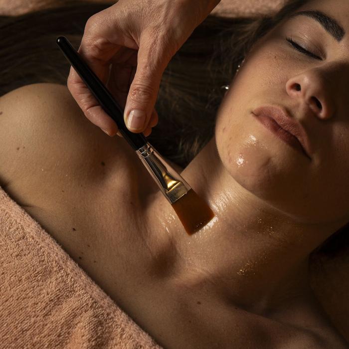 Brush caresses skin, relaxing and serene moment of self-care.