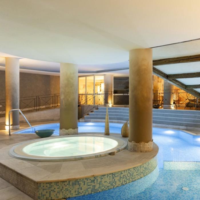 Elegant indoor pool with soft lighting and a relaxing atmosphere.