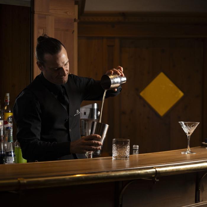 Elegant bartender passionately crafting cocktails in a cozy bar.