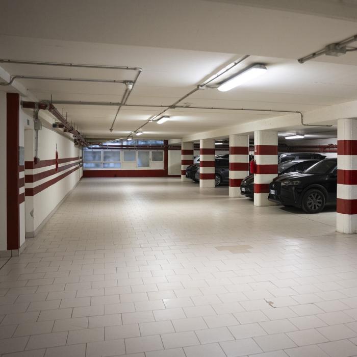 Underground parking, parked cars, calm and orderly atmosphere.
