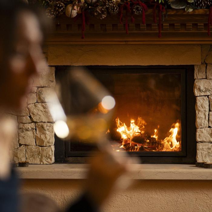 Warm fireplace, glass of wine, intimate and cozy atmosphere.