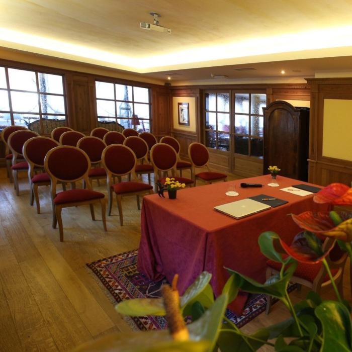 Cozy conference room with red chairs, elegant table, and warm atmosphere.