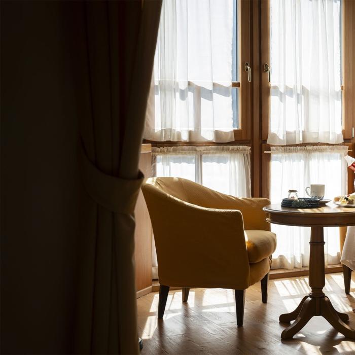 Woman reads in comfort, bathed in warm light and cozy ambiance.