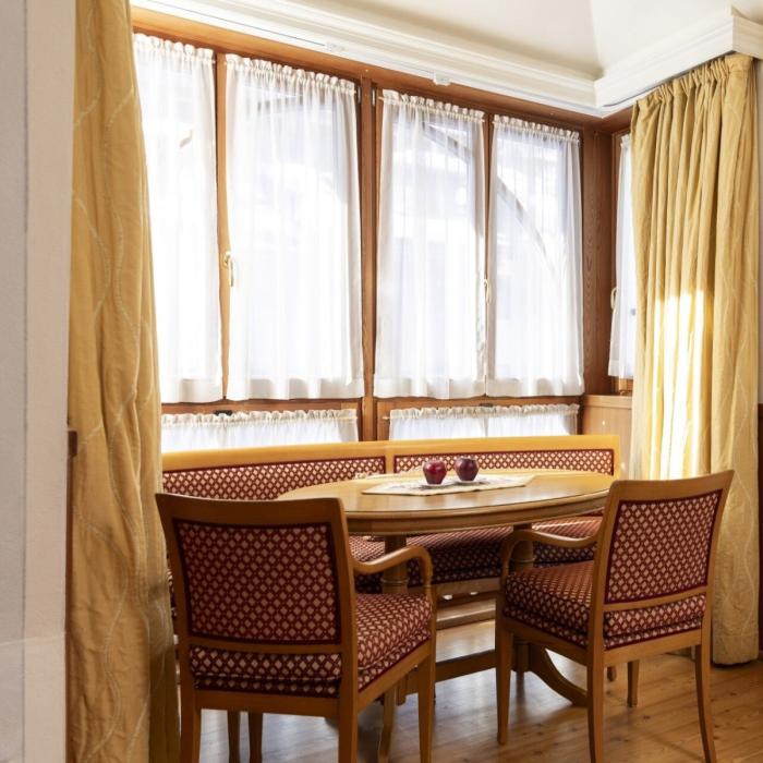 Cozy dining nook with warm wood and soft light from the windows.