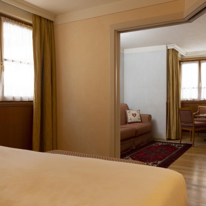 Elegant hotel room with cozy lounge and warm lighting.
