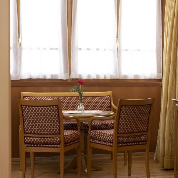 Cozy room with table, chairs, and TV, bathed in warm light.