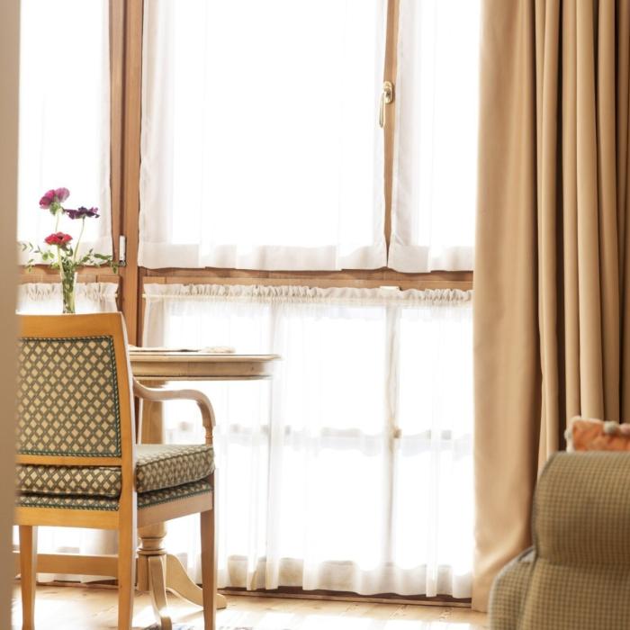 Cozy living room with warm light, fresh flowers, and elegant furnishings.