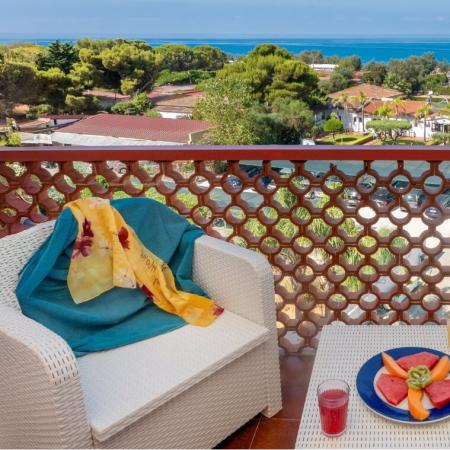 Terrazza con vista mare, frutta fresca e bevande.