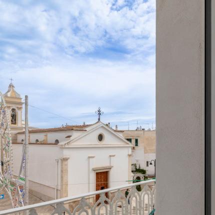 Blick auf eine Kirche von einem Balkon mit wolkigem Himmel.