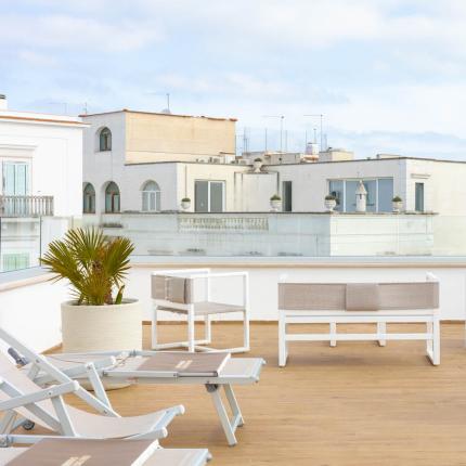 Moderne Terrasse mit Stühlen und Schaukel, Blick auf die Dächer der Stadt.