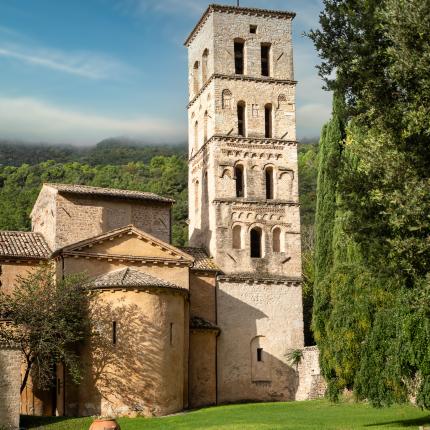 Torre medievale con giardino verde e sedie a sdraio.