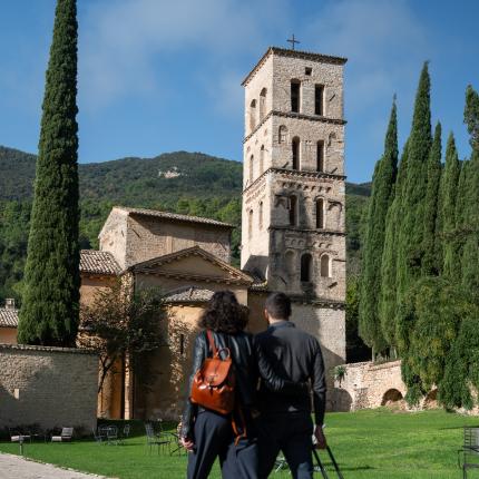 Coppia cammina verso un'antica chiesa con valigia.