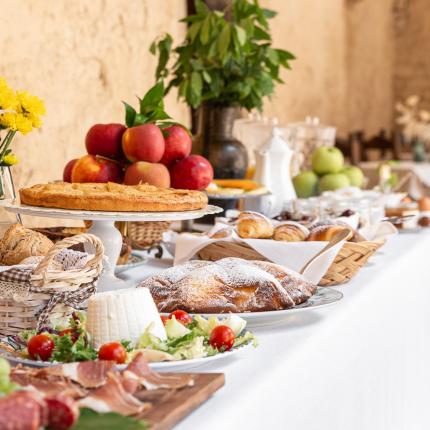 Coppia che fa colazione in un cortile storico.