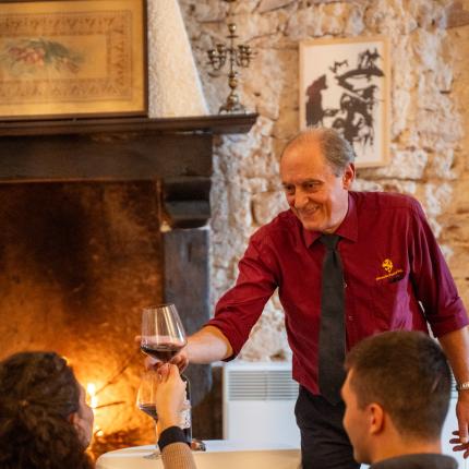 Cameriere serve vino a una coppia in un ambiente accogliente.
