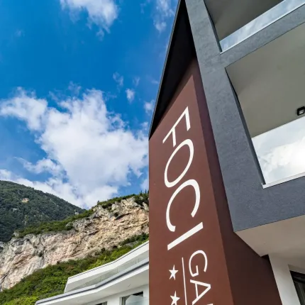 Facciata moderna di hotel tra montagne e cielo blu, atmosfera rilassante.