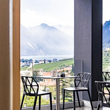Vista mozzafiato su montagne e città da un'elegante terrazza con sedie moderne.