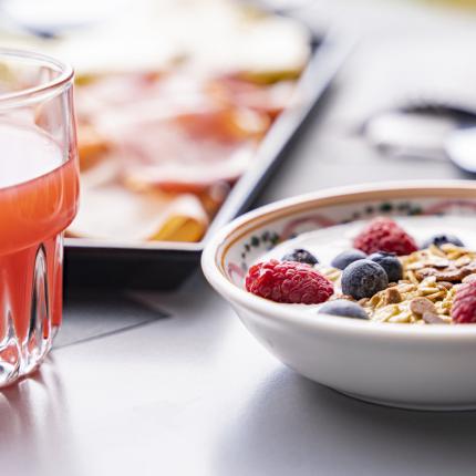 Colazione fresca: yogurt con frutti di bosco e succo di frutta.