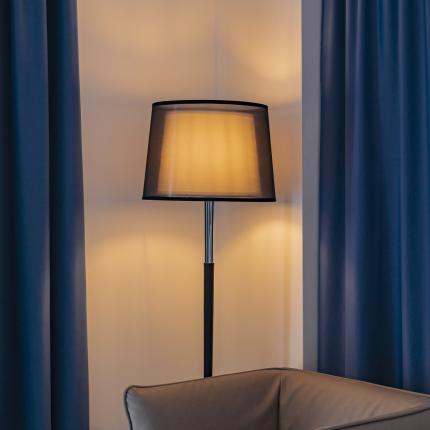 Lampada accesa, tende blu e parete decorata creano un'atmosfera accogliente.